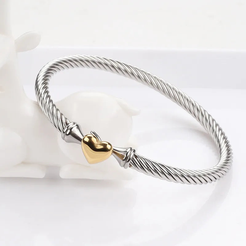 Brazalete Acero Titanio d color plateado con corazon dorado